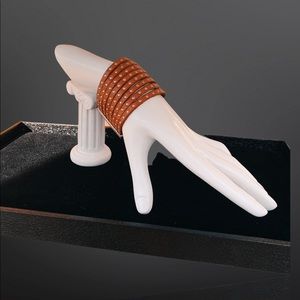 Red leather cuff bracelet with small metal studs and closure.